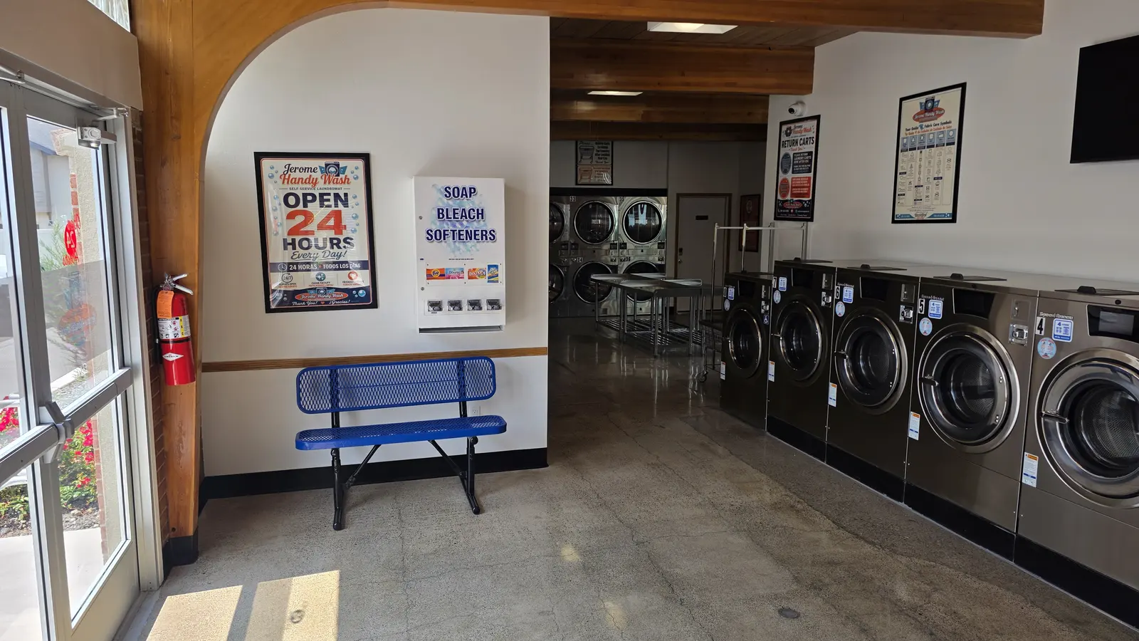 The soap, bleach, and softener vending machine beside a bench near the entrance at Jerome Handy Wash